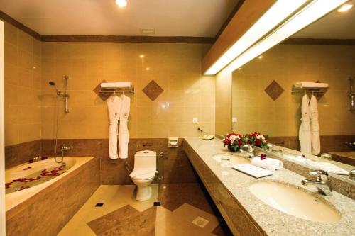 新山纽约酒店的浴室配有盥洗盆、卫生间和浴缸。