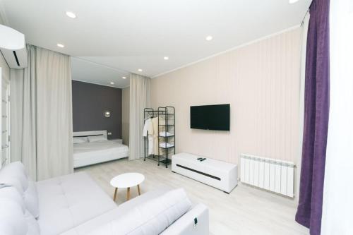 基辅Apartment in Smart Plaza的客厅配有白色沙发和电视