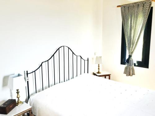 圣彼得罗斯Villa Celest的卧室配有白色的床和窗户。