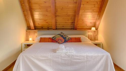 莱斯Saplan Real Estate TERMAS的卧室配有白色的床铺和木制天花板