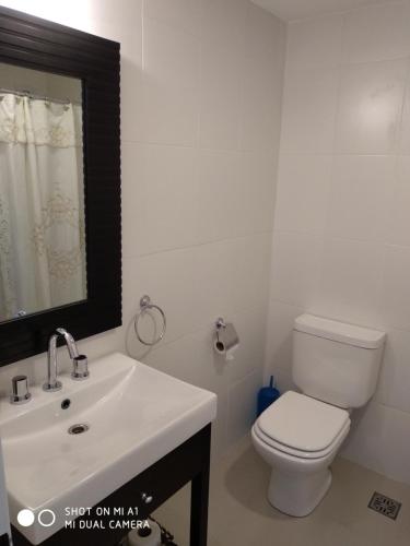 布兰卡港La Suitte的浴室配有白色卫生间和盥洗盆。
