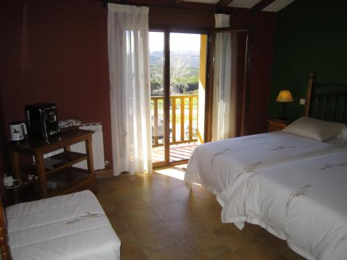 Barajas de GredosHotel Rural La Dehesilla的一间卧室设有一张床和一个阳台的窗户。