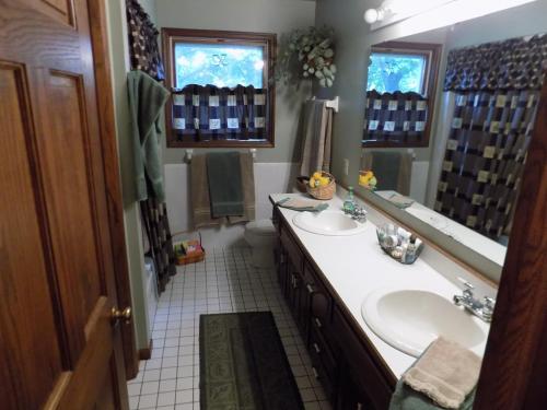 Lake ElmoStoneWall House的一间带两个盥洗盆和大镜子的浴室