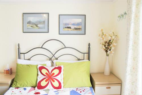 奇切斯特The Witterings Bed and Breakfast的一间卧室配有带绿色和红色枕头的床