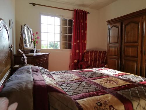AtalaiaCasa Conceição的卧室配有床、椅子和窗户。