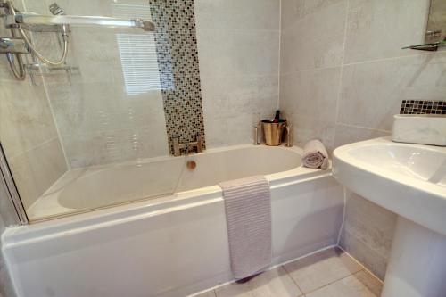 海伦斯堡Chapelhill的白色的浴室设有浴缸和水槽。
