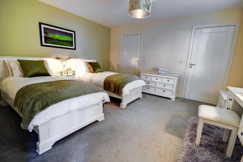 海伦斯堡Chapelhill的一间卧室配有两张床、一张桌子和一把椅子