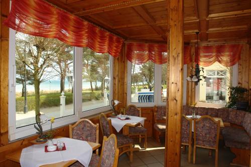 宾茨Strandhotel zur Promenade的餐厅设有桌椅和窗户。