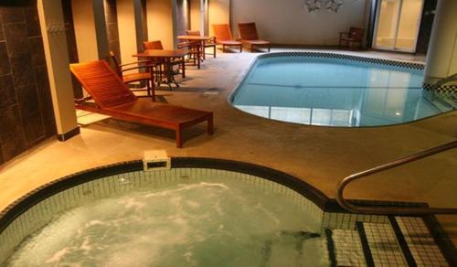 圣乔治斯勒乔治村酒店的一座配有桌椅的酒店游泳池