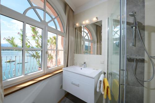 沃尔特湖畔佩莎赫阿斯托利亚酒店的一间带水槽和淋浴的浴室以及窗户。