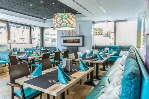 斯拉德明TUI BLUE Schladming的餐厅设有木桌和蓝色椅子
