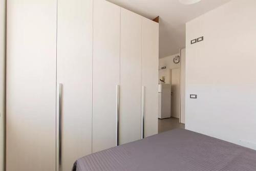 马萨Casa dei Marmi - in Toscana 10 min dal mare的卧室配有白色橱柜和冰箱。
