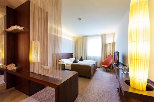 克拉根福Seepark Wörthersee Resort的配有一张床和一张书桌的酒店客房