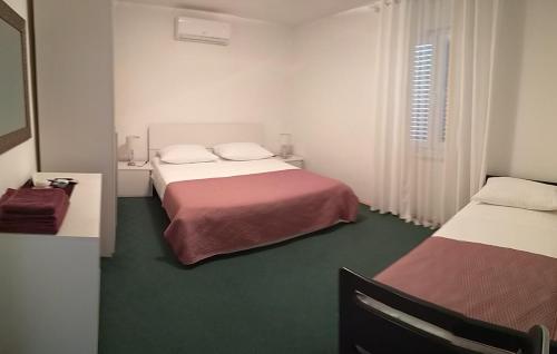 罗佐瓦克Rooms Ive的酒店客房设有两张床和窗户。