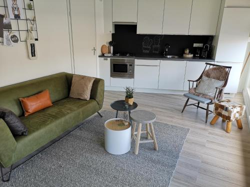 戈伊斯De Kade的客厅配有绿色沙发和桌子