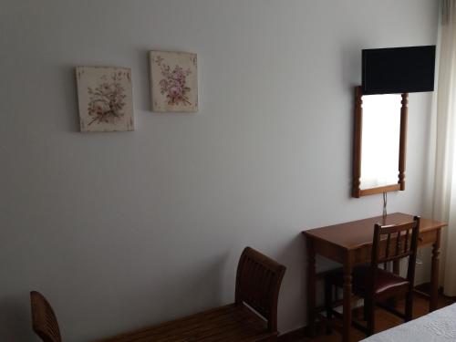 VimianzoPensión Vázquez的一间卧室配有书桌、桌子和窗户。