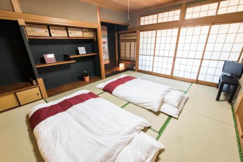 大阪Teradaya Osaka Ryokan 150m2 寺田屋大阪旅館 your own property sweet home in Osaka的配有电视和窗户的客房内的两张床