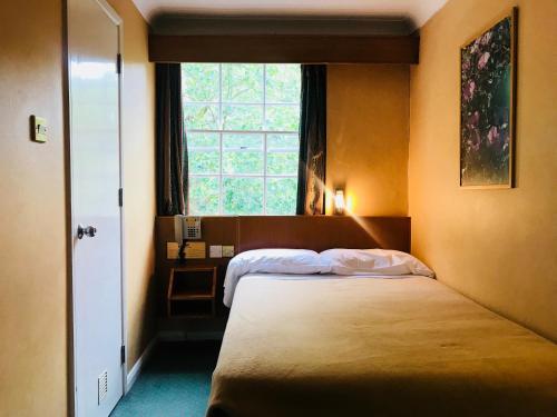 伦敦The Beverley House Hotel的一间卧室设有两张床和窗户。