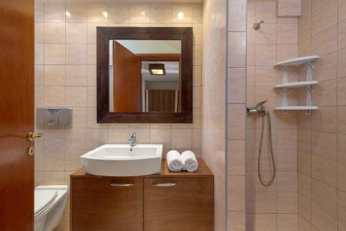 拉卡尼亚Villa Lahania的浴室配有盥洗盆和带镜子的淋浴