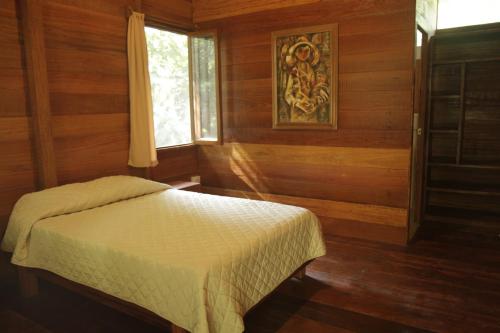塔拉波托La Musa Verde的卧室配有一张床铺,位于带木墙的房间内