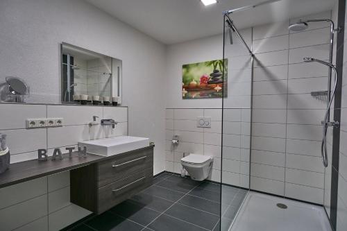 NiederlinxweilerFerienwohnung Atrium的浴室配有盥洗盆、卫生间和淋浴。