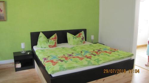 MittelndorfFerienzimmer Haus Läsker的一张带绿色被子和枕头的床
