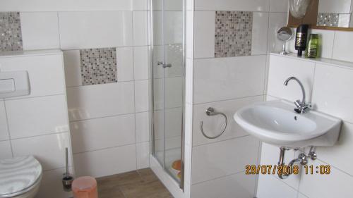 MittelndorfFerienzimmer Haus Läsker的白色的浴室设有水槽和卫生间。