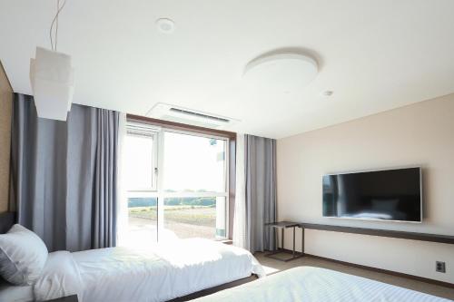 西归浦市济州宋山酒店的酒店客房设有两张床和电视。