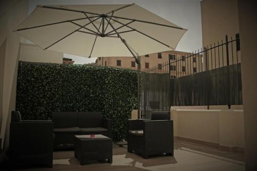 斯培西亚锐欧鲁姆斯旅馆的一个带遮阳伞和椅子的庭院和树 ⁇ 