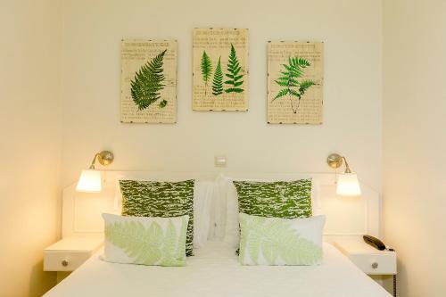 辛特拉诺瓦辛特拉酒店的卧室配有一张四叶海报的床铺,墙上挂着海报
