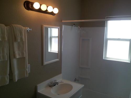 博尔德城绿洲精品汽车旅馆的一间带水槽和卫生间的浴室以及窗户。
