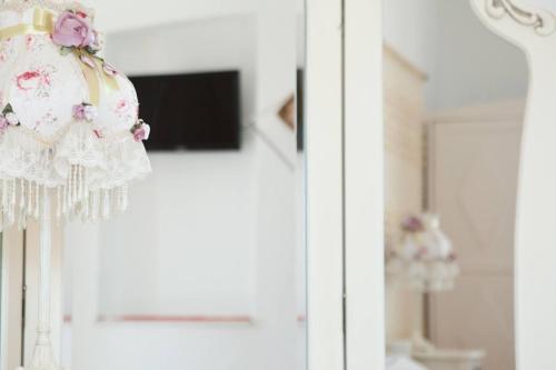 利瓦迪奥Hotel Albatross的白色的连衣裙,窗户上装有粉红色的花朵