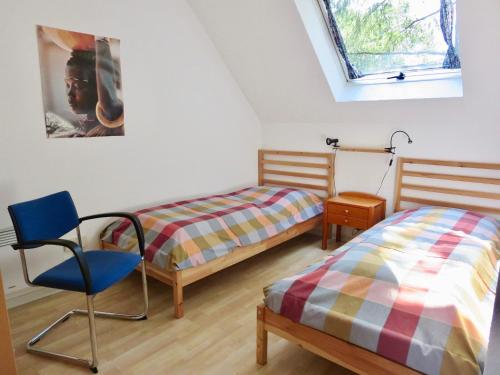 弗兰克瑙Natururlaub Frankenau的一间卧室设有两张床、一把椅子和一个窗户。
