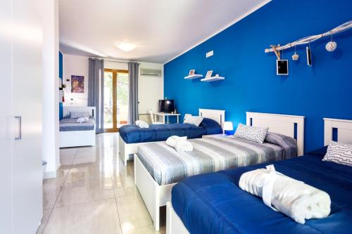 帕泰尔诺Rocca degli Etnei的一间设有三张床和蓝色墙壁的房间