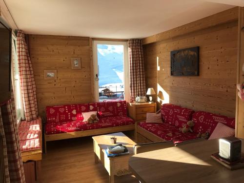 蒂涅Prariond 5的客厅设有红色的沙发和窗户