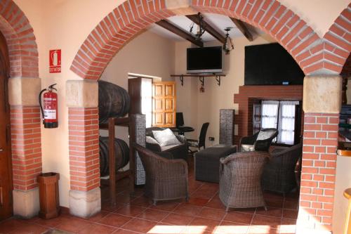 La BustaTrisileja en Posada La Busta的客厅设有拱门、椅子和壁炉