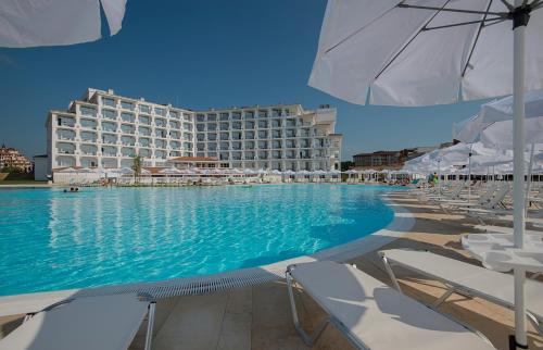 奥布佐尔Sunrise Blue Magic Resort - All Inclusive的酒店设有带椅子和遮阳伞的游泳池