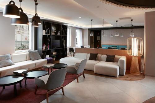 科尔马科尔马中心诺富特酒店的客厅配有沙发、椅子和桌子