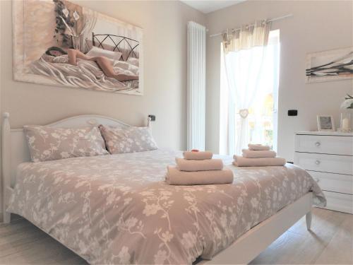 Ponte CaffaroLago d'Idro - Casa Emma的一间卧室配有一张床,上面有两条毛巾