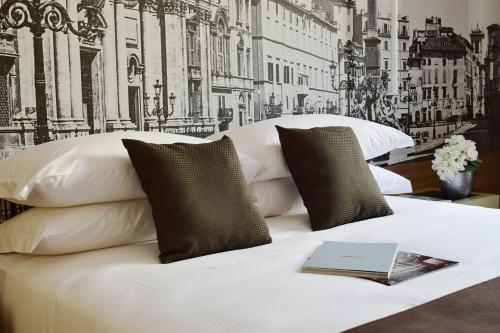 罗马阿基米德莱里酒店的一间卧室配有一张床,上面有一本书