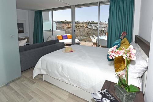 阿马多雷斯Beyond Amadores C&H Suite的卧室配有一张白色的大床和一张沙发。