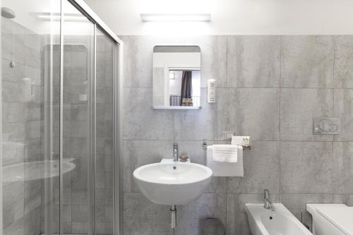科玛南扎Interamnia Boutique Hotel的一间带水槽和玻璃淋浴的浴室