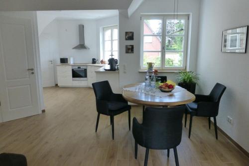 罗埃特根Ferienwohnung am Eifelsteig的厨房以及带桌椅的用餐室。