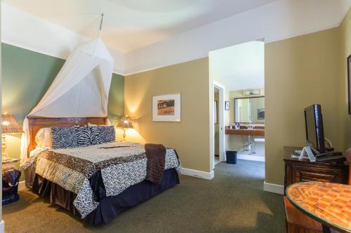圣拉斐尔Panama Hotel and Suites的一间卧室配有一张带天蓬的床