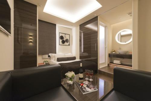 横滨HOTEL ROY(Adult Only)的客房设有床、沙发和桌子。