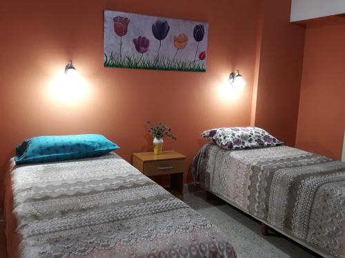 布兰卡港Departamento Luiggi con cochera的一间卧室设有两张床,墙上挂着一幅画