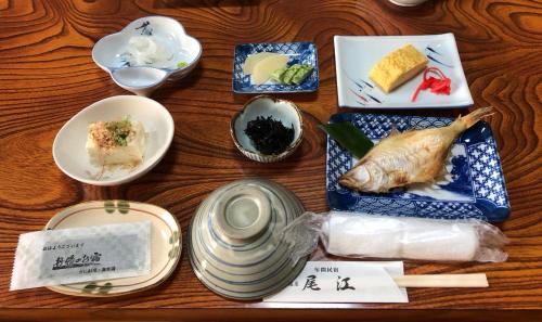 京丹后市大江宾馆的餐桌上放有盘子和碗的食物