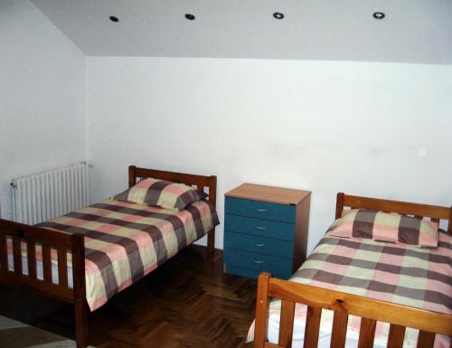 萨拉热窝Apartman "Beban"的一间带两张床和蓝色梳妆台的卧室