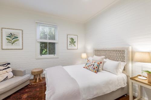 科夫斯港杰特度假屋的白色的卧室设有床和窗户