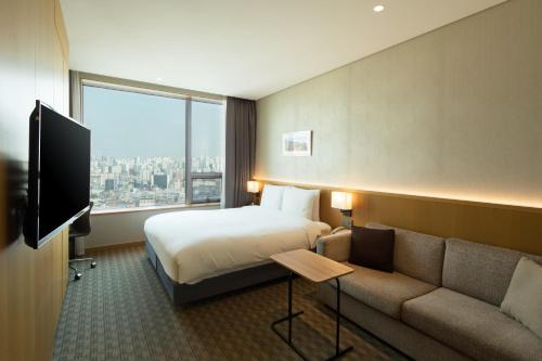 首尔喜普乐吉酒店首尔东大门的酒店客房,配有床和沙发